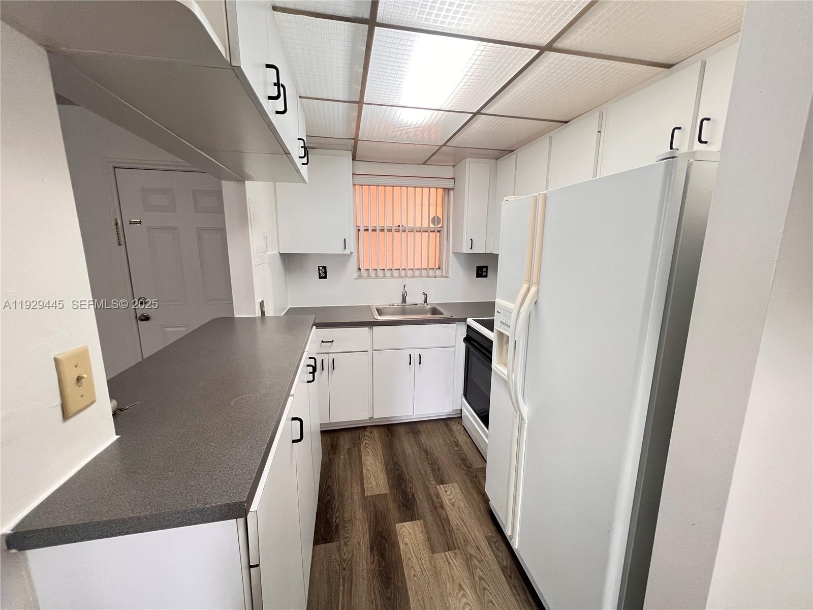 1855 West 60th Street, Unit 430 Hialeah, FL 33012 - Photo 7 of 16 a kitchen with a refrigerator a sink and dishwasher