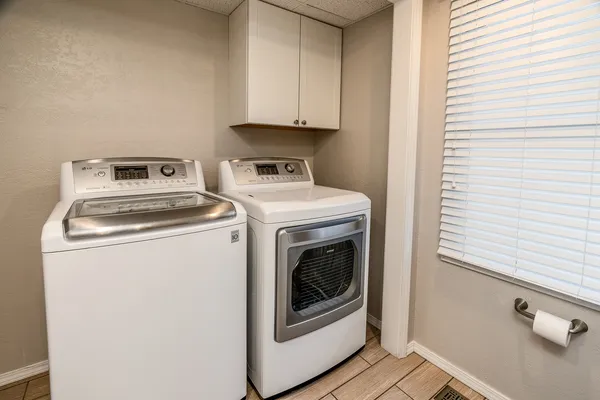 an empty room with ceiling fan and windows