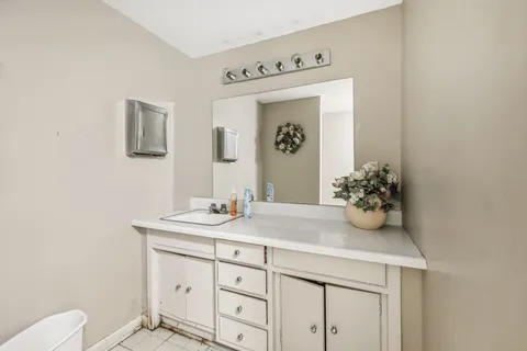 a bathroom with a granite countertop sink and a mirror