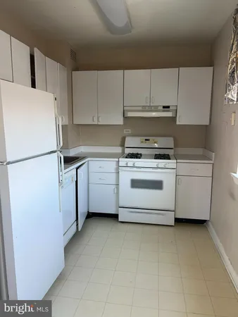 a kitchen with cabinets and white stainless steel appliances