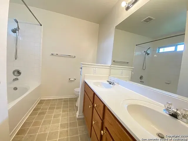 a bathroom with a sink double vanity granite tub shower and a mirror