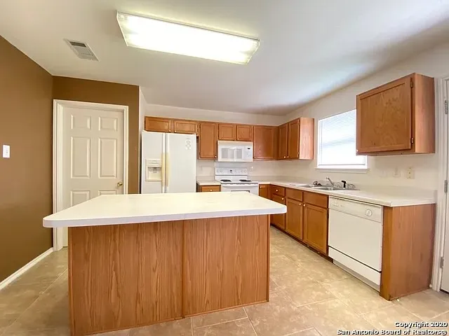 a large kitchen with stainless steel appliances granite countertop a sink and a stove