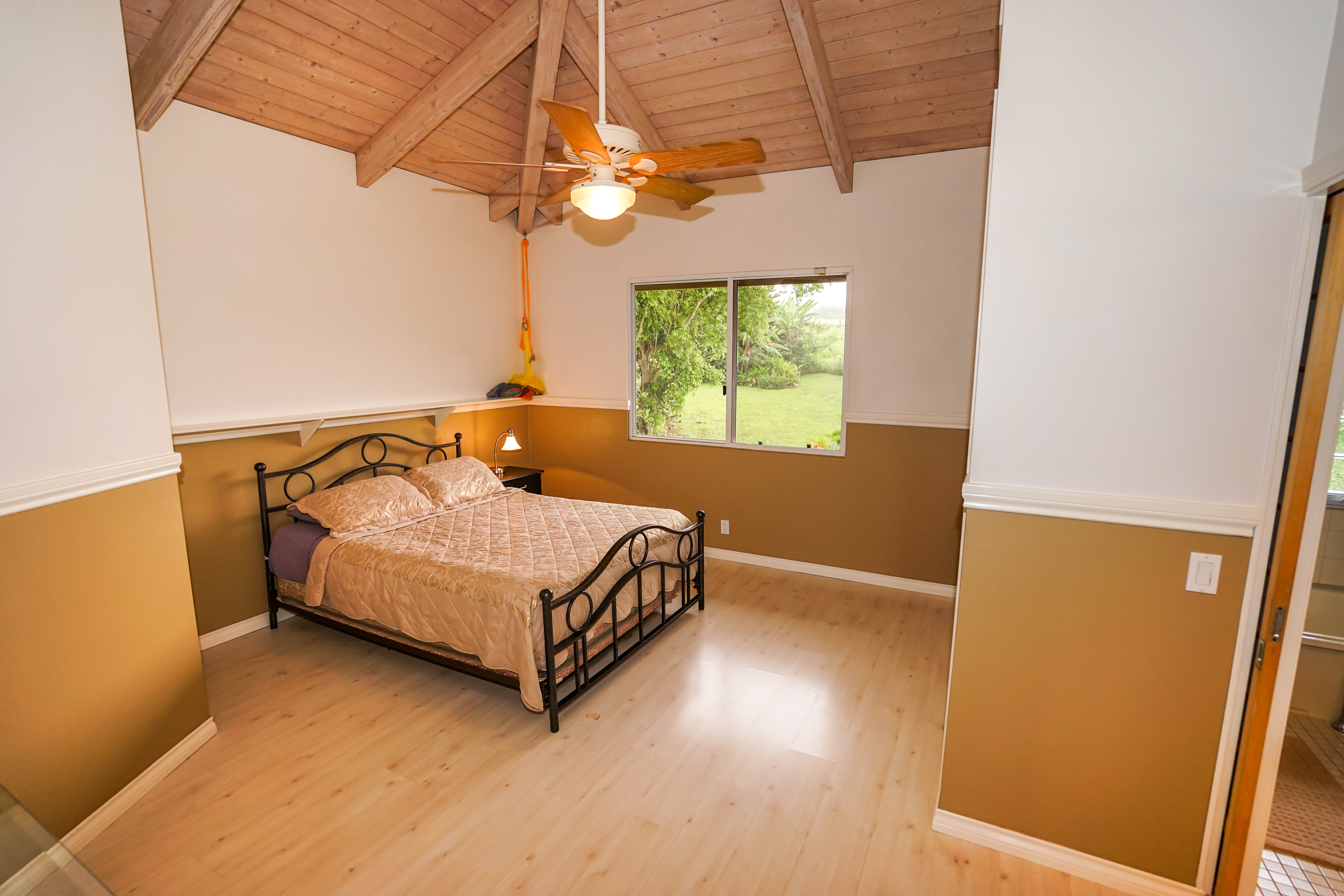 4700 Kapuna Road Kilauea, HI 96754 - Photo 11 of 17 a bed sitting in a room next to a window