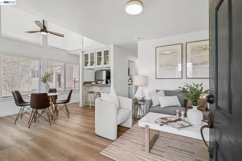 a living room with furniture a dining table and a potted plant