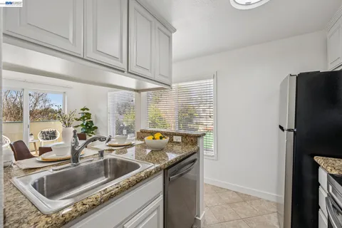 a kitchen with stainless steel appliances granite countertop a sink and a refrigerator