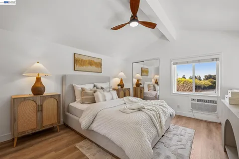 a bedroom with a bed and wooden floor