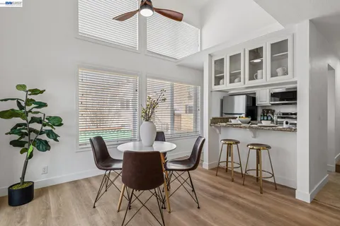 a dining room with furniture potted plants and wooden floor