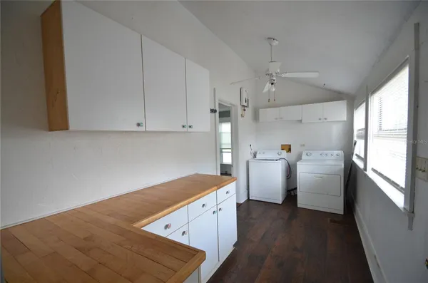 a view of a kitchen with white cabinets and wooden floor