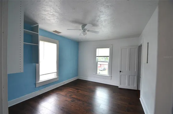 a view of a hallway with wooden floor and stairs