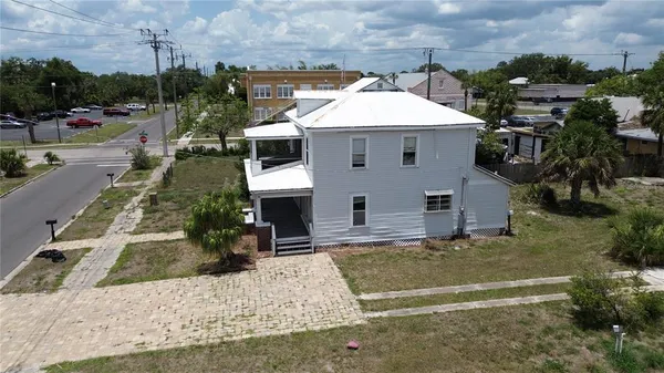 a view of a white house with a yard table and chairs
