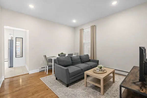 a living room with furniture and a wooden floor