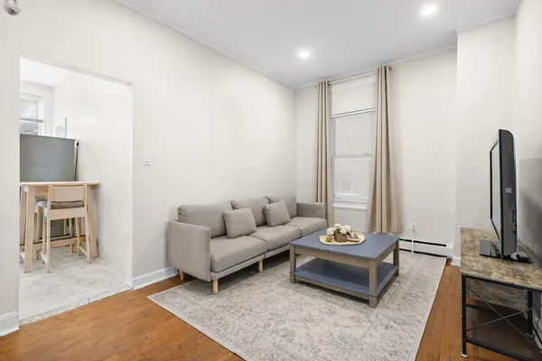 a living room with furniture a flat screen tv and a fireplace