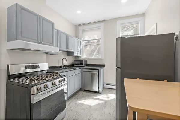 a kitchen with cabinets appliances and a window