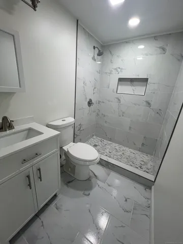 a bathroom with a sink a toilet and shower