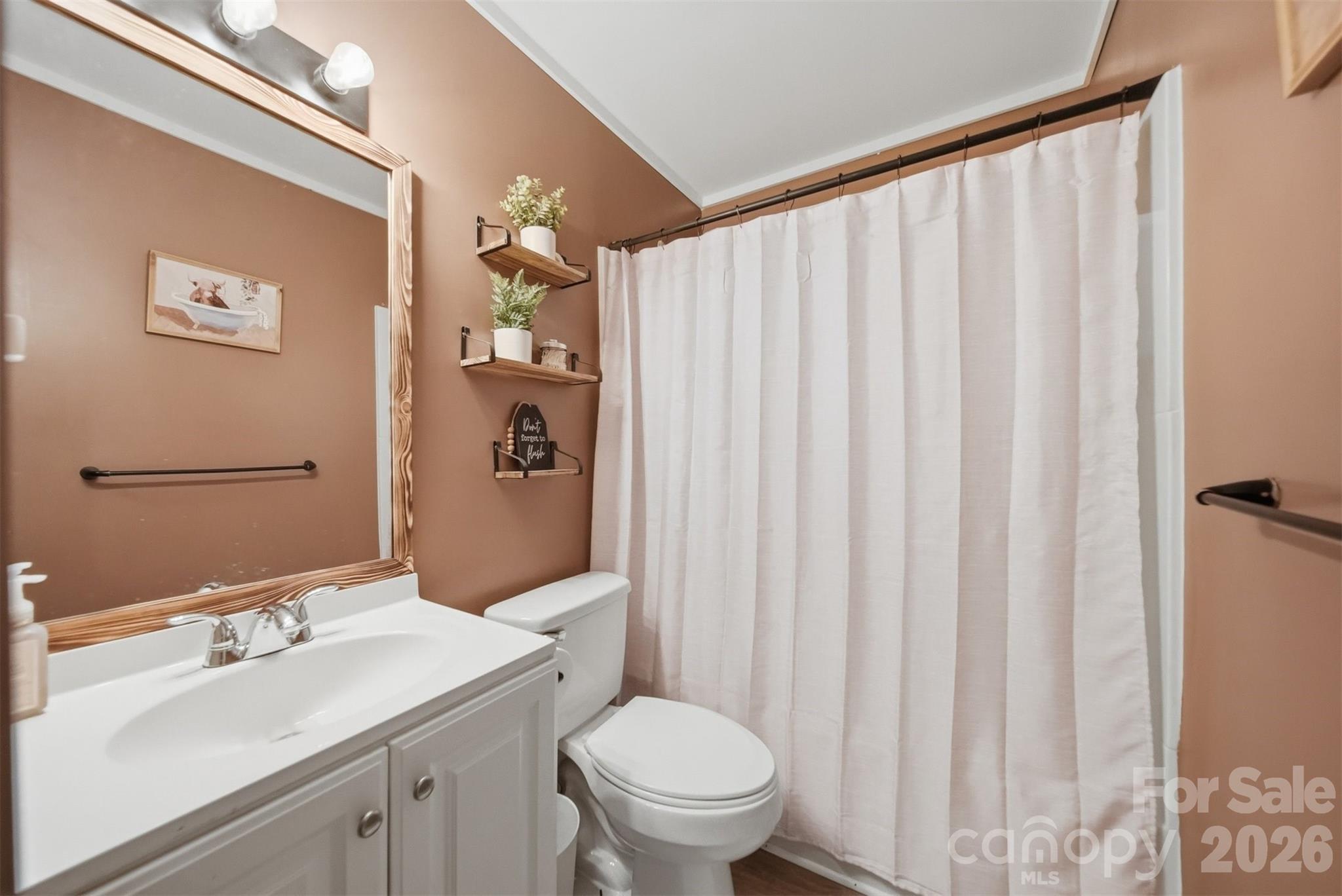 1312 County Home Road Conover, NC 28613 - Photo 16 of 25 a bathroom with a sink a toilet and shower curtain