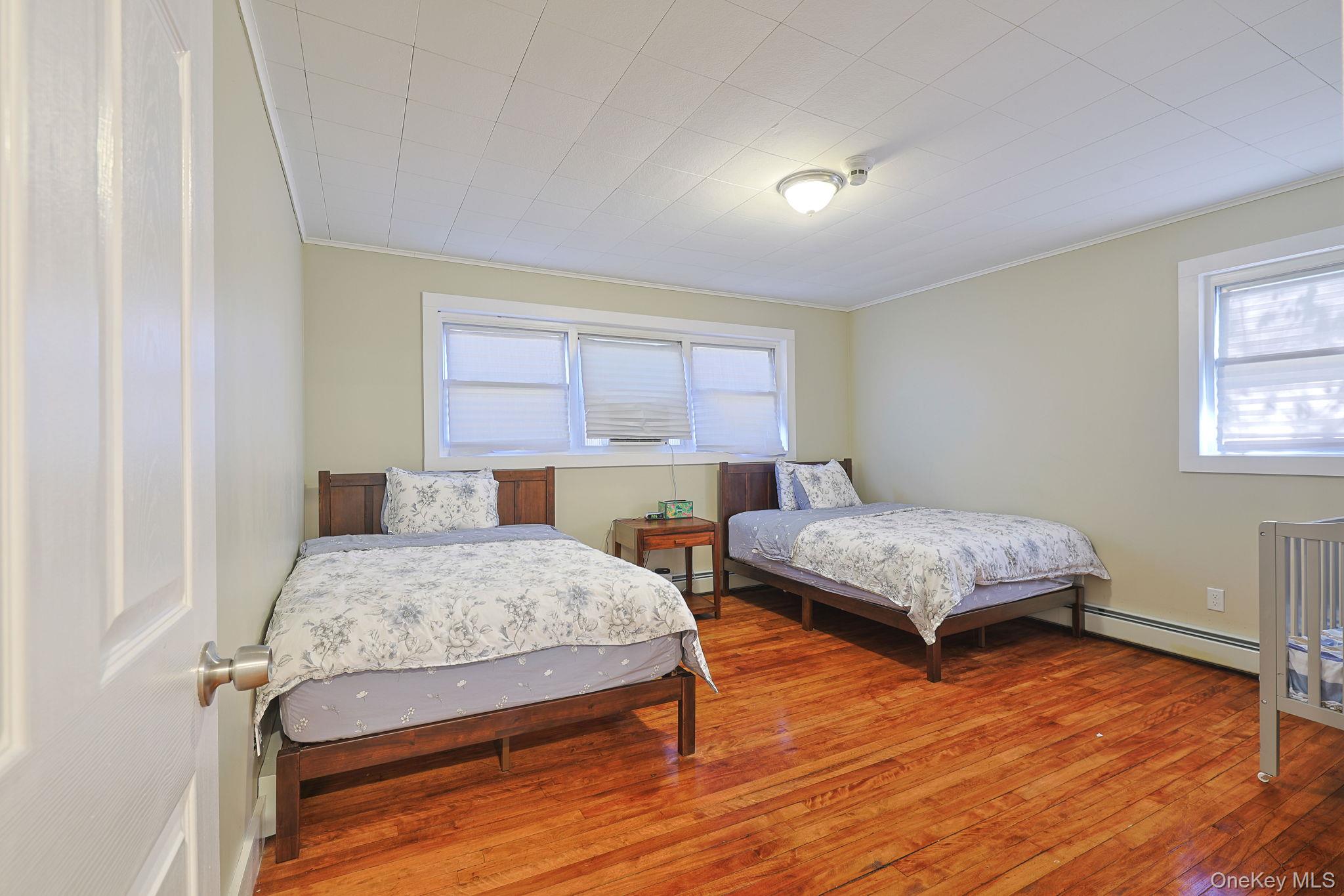 30 Rock Ridge Avenue Monticello, NY 12701 - Photo 12 of 19 a bedroom with a bed a chandelier and a window
