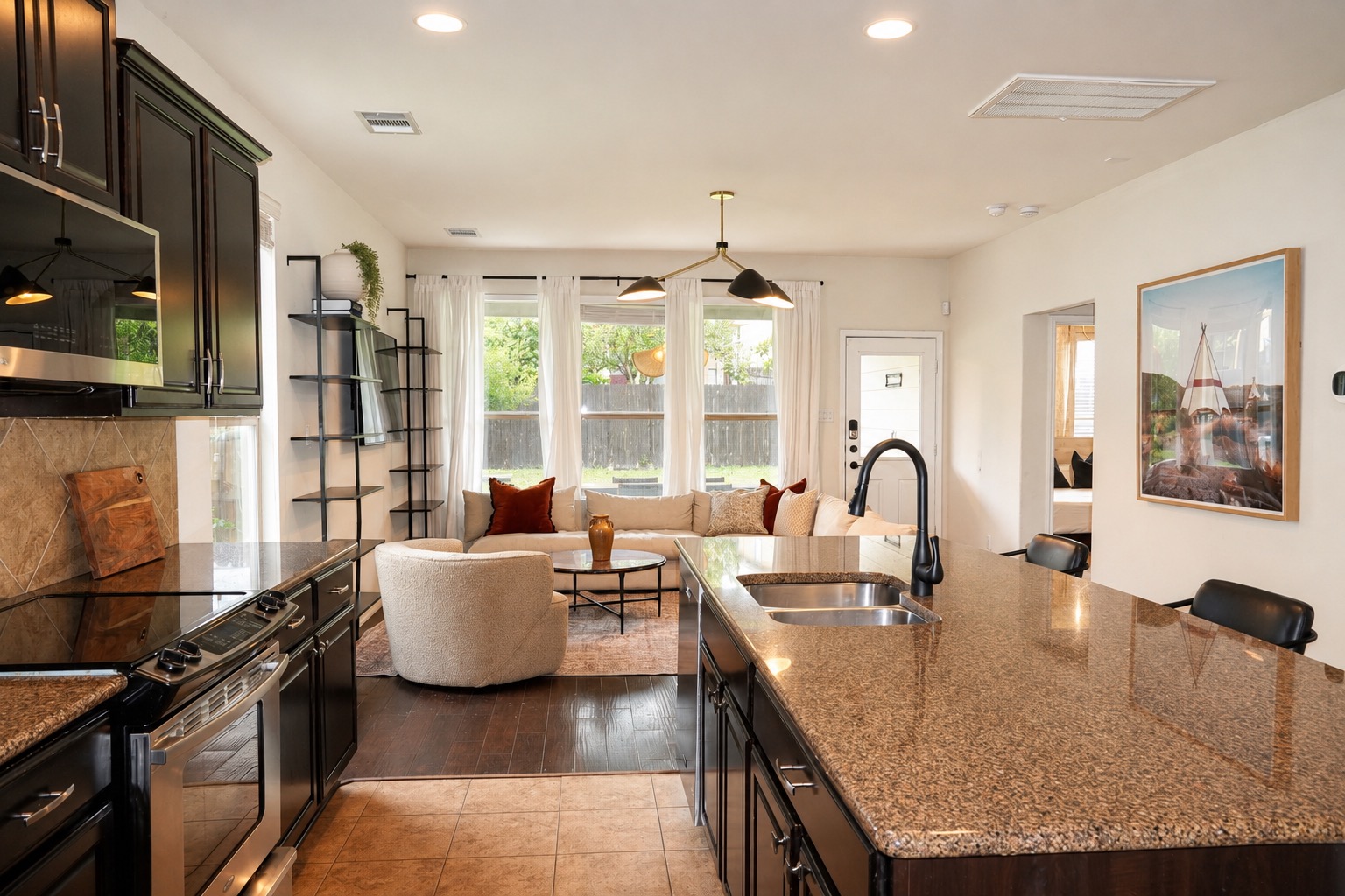 9929 Wading Pool Path Austin, TX 78748 - Photo 5 of 13 An inviting open-concept living area boasts a well-appointed kitchen island and abundant natural light from large windows.