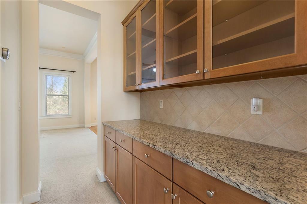 804 Morganton Drive Suwanee, GA 30024 - Photo 26 of 43 a kitchen with granite countertop white cabinets and a wooden floor