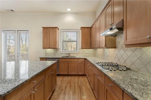 a kitchen with sink a stove and cabinets