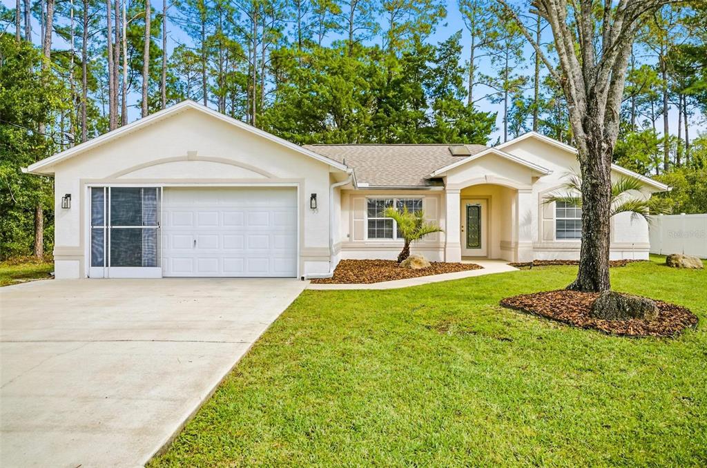 55 Rippling Brook Drive Palm Coast, FL 32164 - Photo 1 of 1 a front view of a house with a yard and trees