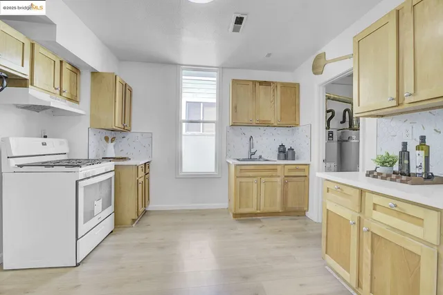 a kitchen with a white stove top oven sink and cabinets