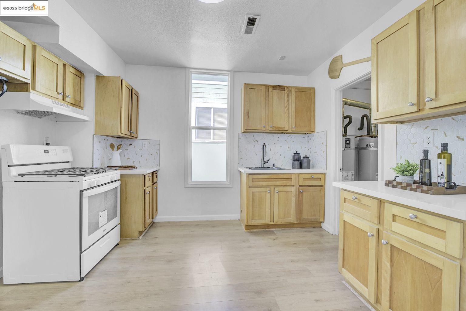 3830 Clarke Street Oakland, CA 94609 - Photo 21 of 41 a kitchen with a white stove top oven sink and cabinets