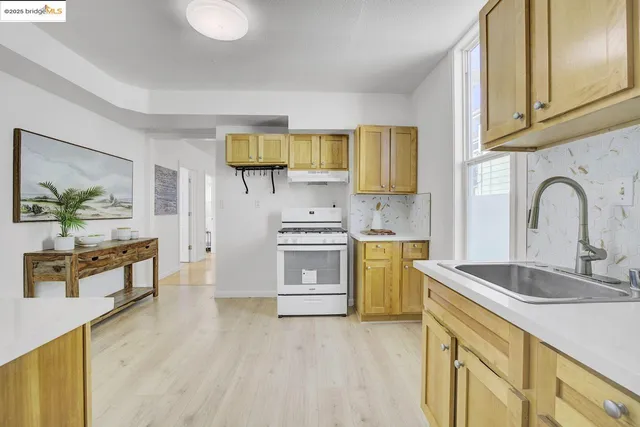 a kitchen with stainless steel appliances granite countertop a sink a stove cabinets counter space and wooden floor