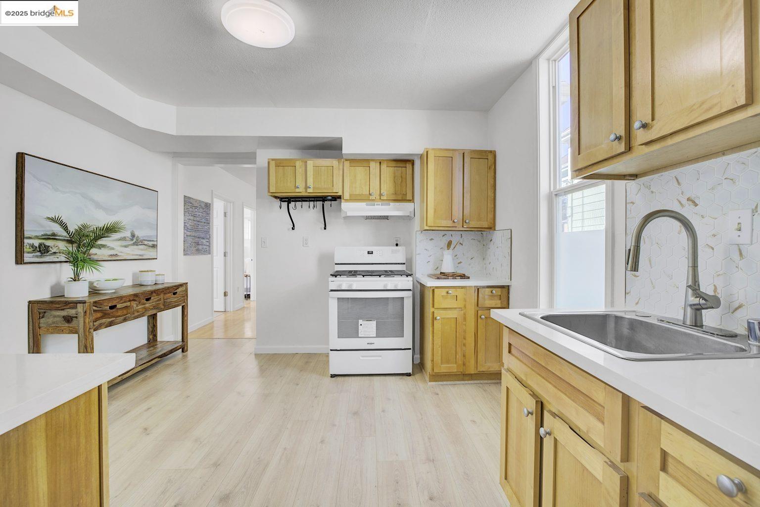 3830 Clarke Street Oakland, CA 94609 - Photo 23 of 41 a kitchen with stainless steel appliances granite countertop a sink a stove cabinets counter space and wooden floor