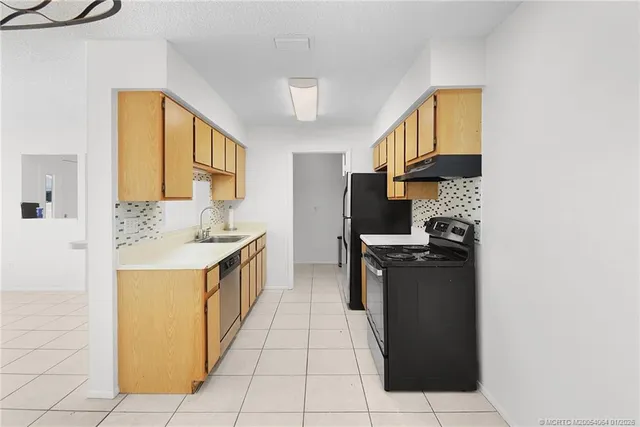 a kitchen with a sink a refrigerator and a stove top oven