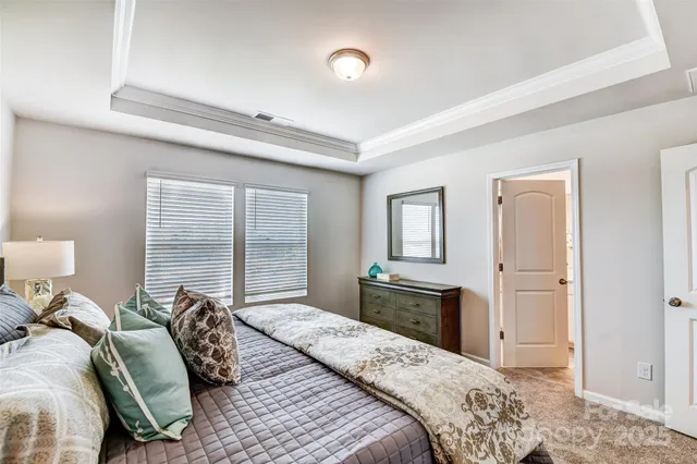 a bedroom with a bed and a dresser with mirror