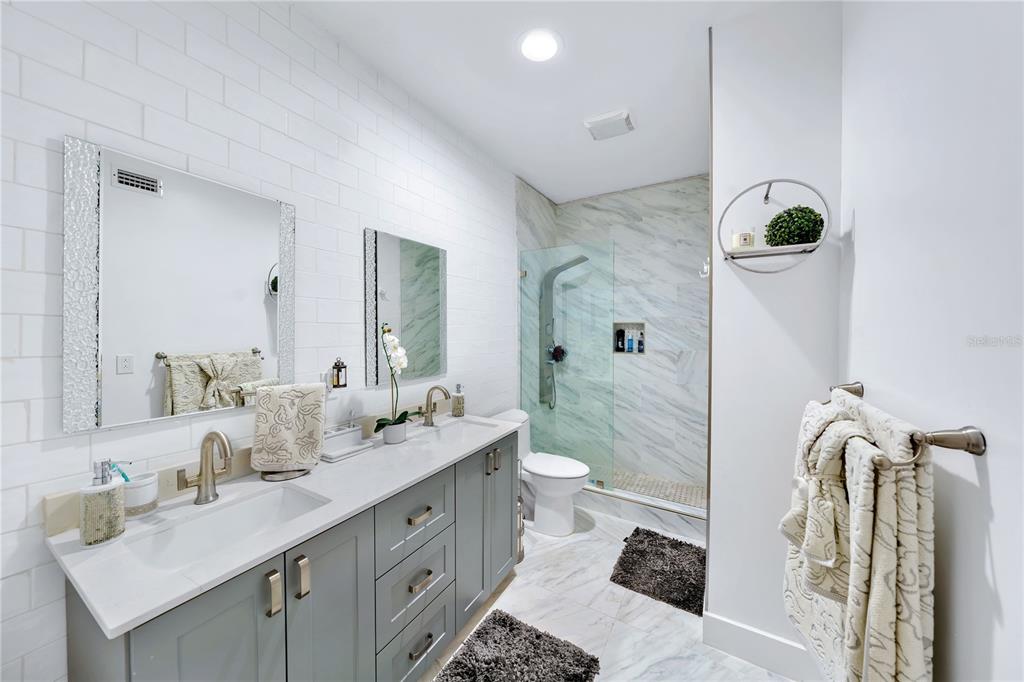 11 Island Avenue, Unit 309 Miami Beach, FL 33139 - Photo 24 of 28 a bathroom with a double vanity sink a toilet and shower