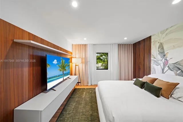 a bedroom with a bed and a large window