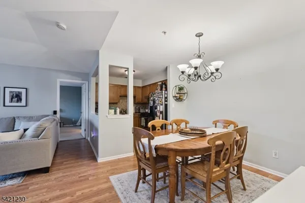 a dining room with furniture wooden floor a rug and a chandelier