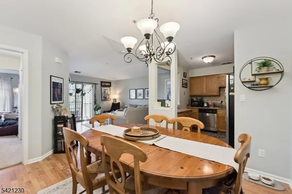 a view of a dining room with furniture a chandelier and wooden floor
