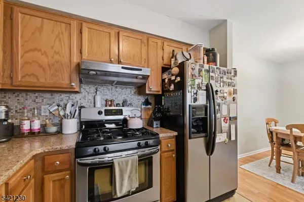 a kitchen with stainless steel appliances granite countertop a stove and a refrigerator