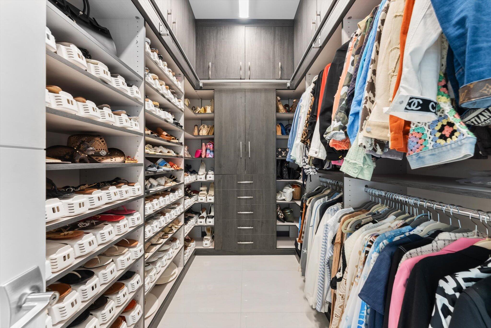 9794 Chianti Classico Terrace Boca Raton, FL 33496 - Photo 61 of 118 a view of walk in closet with clothes and shoes