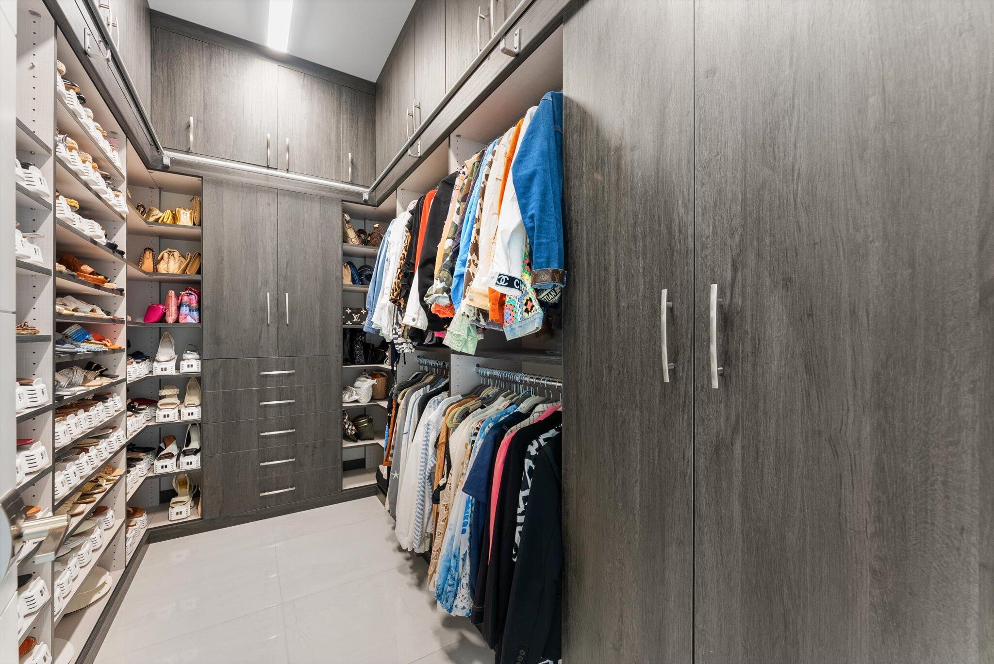 9794 Chianti Classico Terrace Boca Raton, FL 33496 - Photo 63 of 118 a view of walk in closet with clothes and shoes