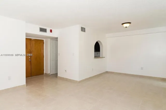 an empty room with closet and windows