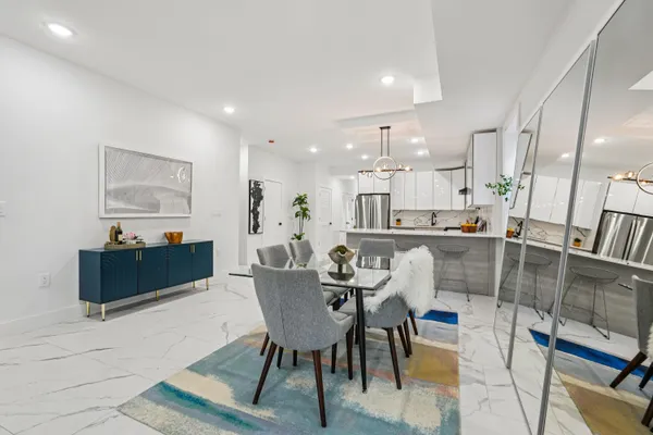 a dining hall with stainless steel appliances kitchen island granite countertop a dining table and chairs