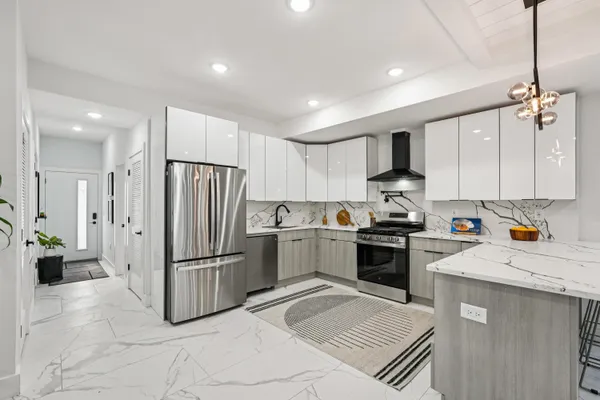 a kitchen with a refrigerator a sink and white cabinets