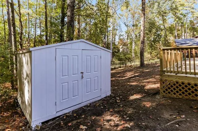 a view of a house with a large tree and wooden fence