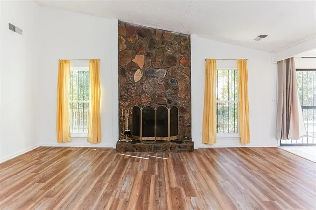 a view of a livingroom with wooden floor and a fireplace