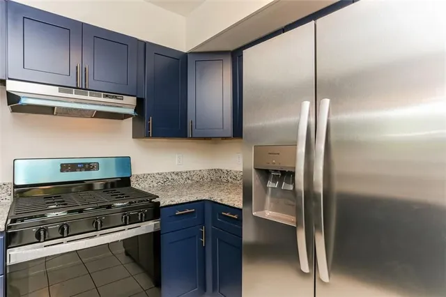 a kitchen with granite countertop stainless steel appliances and wooden cabinets