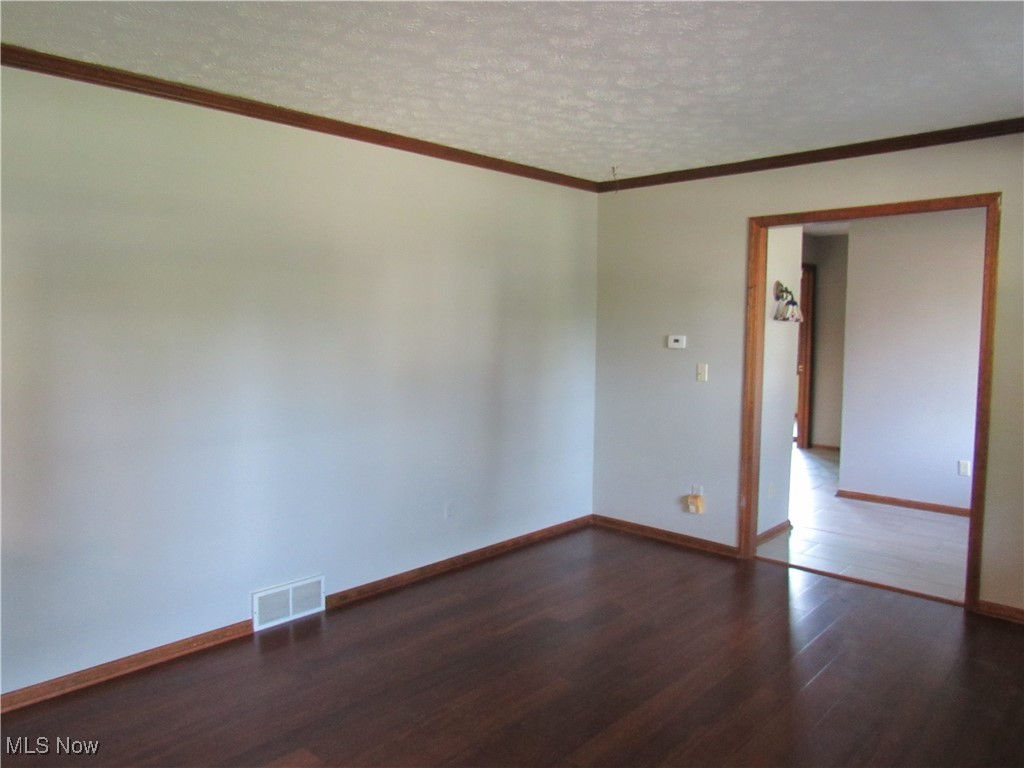 1120 Vincent Road Southeast North Canton, OH 44720 - Photo 8 of 50 Formal Living Room with crown molding, a textured ceiling, and Bamboo flooring