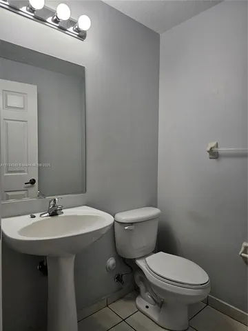 a bathroom with a sink a toilet and mirror