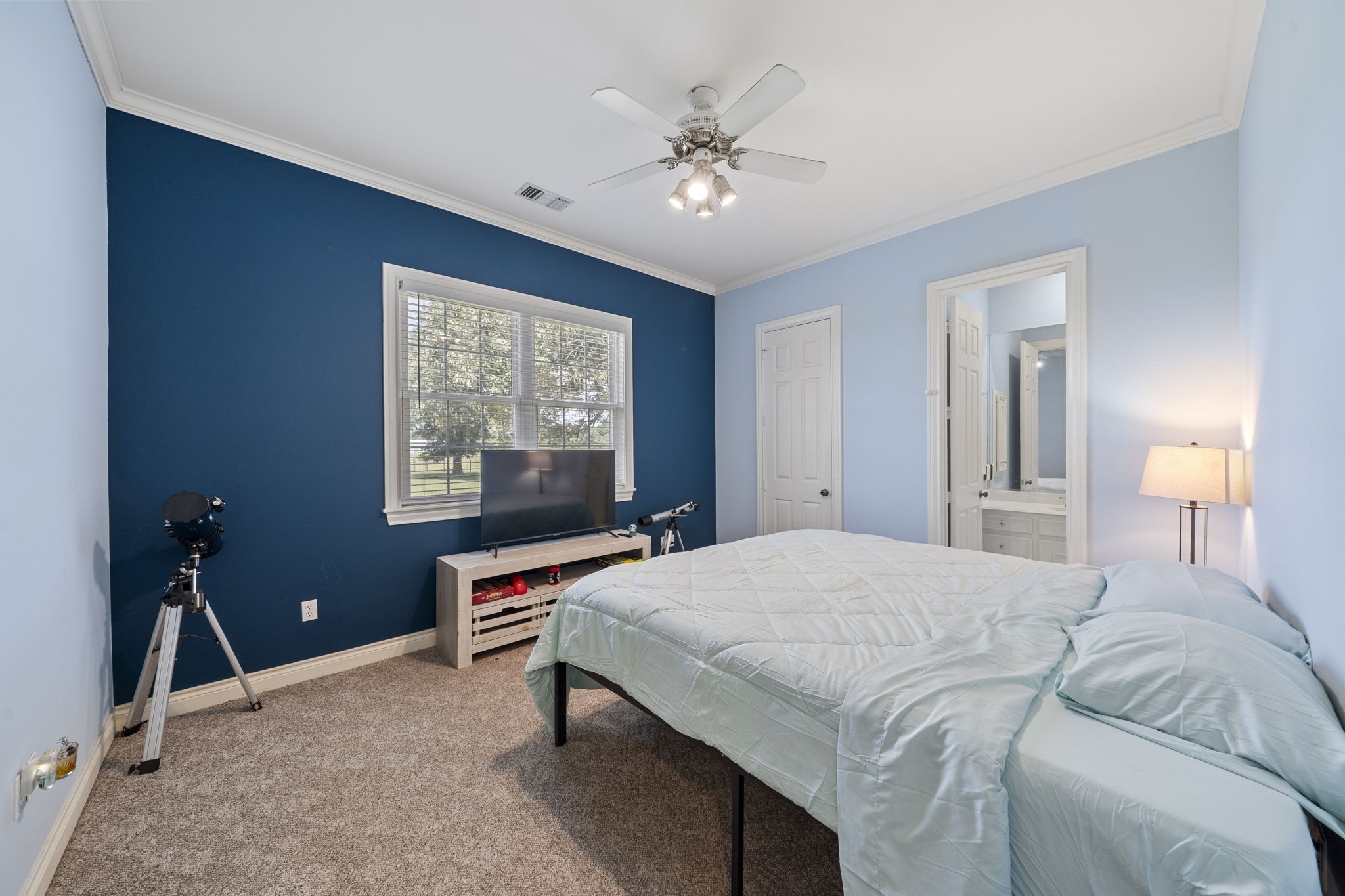 35111 Tompkins Road Hempstead, TX 77445 - Photo 25 of 50 a bedroom with a bed and a chandelier