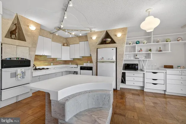 a kitchen with stainless steel appliances kitchen island granite countertop a refrigerator and cabinets