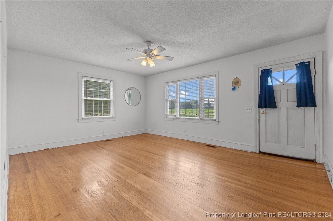 430 Simmons Road Clinton, NC 28328 - Photo 7 of 30 a view of empty room with wooden floor and fan