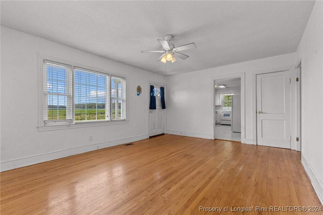 430 Simmons Road Clinton, NC 28328 - Photo 8 of 30 a view of empty room with wooden floor and fan