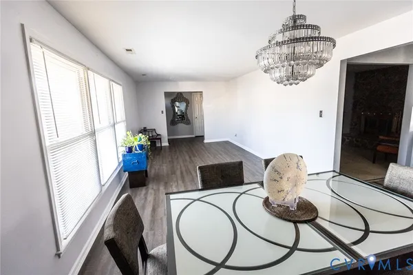 a living room with furniture a chandelier and a flat screen tv